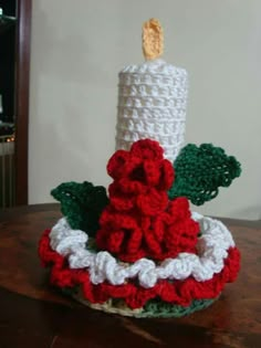 a crocheted candle sits on top of a table