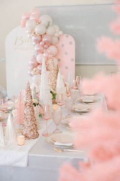 the table is set with pink and white decorations