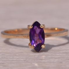 This Stunning Piece, Known As The Amethyst Charm, Features A Captivating Marquise Cut Natural Amethyst. The Vibrant Purple Gemstone Is Elegantly Set In A Classic Yellow Gold Band, Adding A Touch Of Brilliance And Sophistication. The Ring Is Currently A Finger Size 6.25 Yet Can Be Adjusted To Any Finger Size For An Additional Charge Upon Request, Ensuring A Perfect Fit. Yellow Gold Color, Vibrant Purple, Marquise Cut, Amethyst Ring, Gold Band, Womens Jewelry Rings, Gold Bands, Gold Color, Amethyst