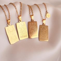 three gold necklaces with different designs on them