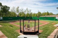 an empty baseball field with people playing on the field and in the outfield area