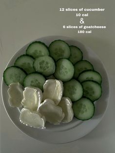 sliced cucumbers and slices of goat cheese on a white plate with calories