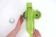 a person is holding the handle on a green object