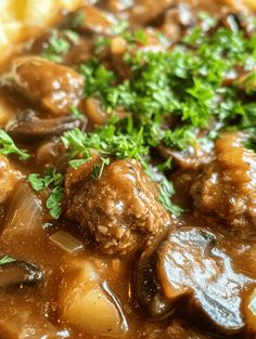 meatballs and gravy on top of mashed potatoes with garnish