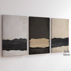 three abstract paintings hanging on the wall next to each other, one black and one white