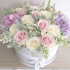 a bouquet of flowers sitting on top of a white box with a ribbon around it