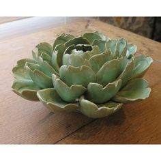 a large green flower sitting on top of a wooden table