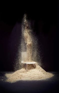 a chair is sprinkled with sand as it sits on top of a table