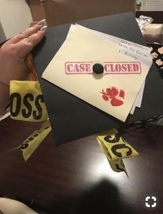 someone is holding up a graduation cap with the word case closed on it and some yellow tape