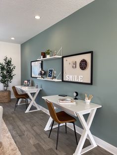 a living room with two chairs and a white table in front of a blue wall