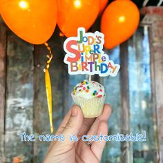 a hand holding a cupcake with candles and balloons in the background that says, jods super happy birthday