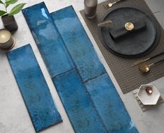 a table with blue tiles on it and other items around it, including a candle holder