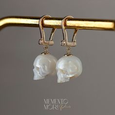 💀CUSTOM made to order Every single piece is hand-carved for the order. Please notice that every skull piece is unique and may have a slightly different shape  💀PEARLS:  Genuine White Freshwater Pearls  Ranging in size, from 11mm to 12mm.  💀Earrings: 14K Yellow Gold Diamond-Set Lever-Backs 💀 Authentic Metal Quality Guaranteed! Rest assured that all the metal qualities mentioned in the description are accurately represented. Occasionally, due to the small size of the product, a hallmark may not be stamped onto the item. You can verify the authenticity of the metal at any local jewelry store. We prioritize transparency to ensure you receive the quality you expect. 💀 𝕿𝖍𝖆𝖓𝖐 𝖞𝖔𝖚 𝖋𝖔𝖗 𝖘𝖍𝖔𝖕𝖕𝖎𝖓𝖌 𝖜𝖎𝖙𝖍 𝕸𝖊𝖒𝖊𝖓𝖙𝖔 𝕸𝖔𝖗𝖎 𝕻𝖊𝖆𝖗𝖑𝖘! Luxury Skull Shaped Jewelry For Gift, Luxury Skull Jewelry For Gifts, Elegant Handmade Bone-colored Jewelry, White Pearl Earring, Gothic Earrings, Local Jewelry, Skull Earrings, White Freshwater Pearl, Gothic Jewelry