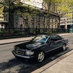 a black mercedes benz coupe parked on the street