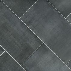 a close up view of a black tile floor with grey grouting on it