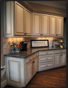 a large kitchen with white cabinets and granite counter tops, along with hardwood flooring