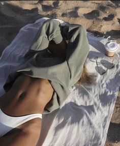 a woman laying on top of a white towel