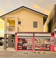 an empty street in front of a building with many items on the outside and inside