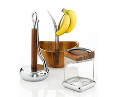 an assortment of kitchen utensils including bananas in a wooden bowl and glass holder