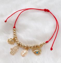 "Protection bracelet MATERIAL AND SIZE 18k gold filled balls 18k Gold filled charms (elephant, hamsa, St Benedict and eye) Adjustable 5.5\" up to 8.5\" Red or Black String If you have questions about the product, feel free to reach me out. Don't forget to check out my other items in the store: Https://www.etsy.com/shop/nyahwithlove" Adjustable Gold Evil Eye Bracelet, Adjustable Gold Evil Eye Symbolic Bracelet, Gold Adjustable Evil Eye Bracelet, Spiritual Gold Beaded Bracelets With Charms, Adjustable Gold Evil Eye Bracelet With Charms, Adjustable Gold Charm Bracelet With Evil Eye, Gold Resizable Evil Eye Spiritual Bracelet, Gold Resizable Spiritual Evil Eye Bracelet, Gold Symbolic Bracelet With Evil Eye