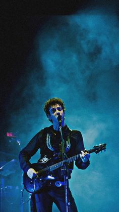 a man with an electric guitar on stage