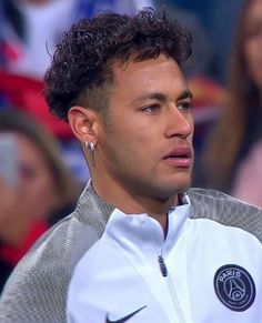 a close up of a person wearing a jacket and ear piercings on his head