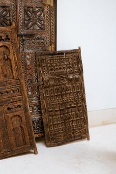 two wooden doors sitting next to each other on top of a white floor in front of a wall