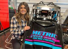 a woman sitting on top of a racing car