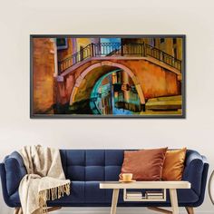 a living room with a blue couch and a painting on the wall above it that has a bridge over water