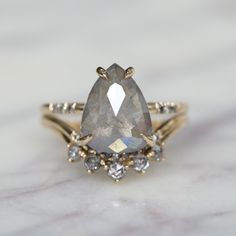 an engagement ring with a pear shaped gray diamond