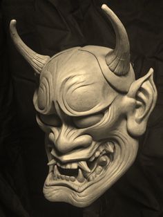 a white mask with horns and fangs on it