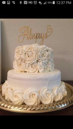 a wedding cake with white frosting and gold lettering that says'always'on top