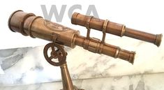 an antique brass telescope on a marble base with the words w c a written below it