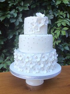 a three tiered white wedding cake with flowers on it