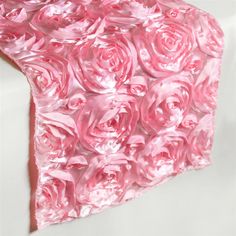 a piece of pink tissue paper with roses on the top and bottom, sitting on a white surface