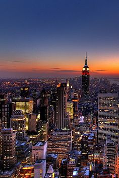 the empire building in new york city at night with lights on and buildings lit up