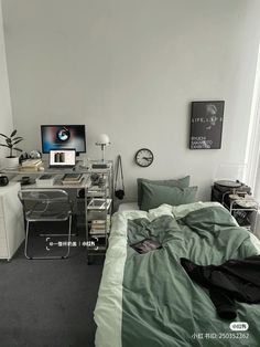 a bedroom with a bed, desk and computer