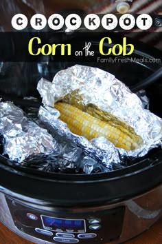 an crock pot with corn on the cob in it and tin foil over top