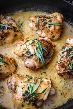 some chicken is cooking in a skillet with gravy and garnish