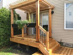 a wooden deck with planters on it next to a house