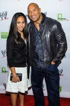 two people standing next to each other on a red carpet