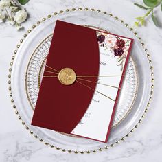 two red and white cards on a plate with gold trimmings, tied together