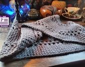 a knitted blanket sitting on top of a wooden table