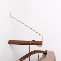 a pair of glasses sitting on top of a wooden hanger next to a white wall