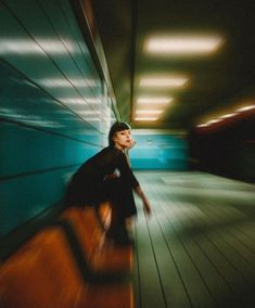 a blurry photo of a woman walking down a hallway with luggage in her hand