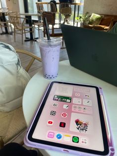 an ipad sitting on top of a table next to a drink