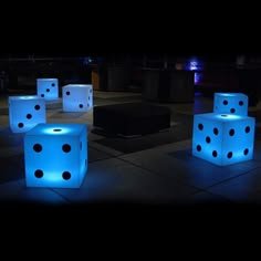 illuminated dices on the ground at night with blue lights and black dots in them