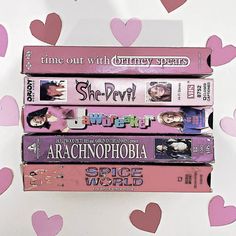 four books stacked on top of each other in front of pink heart shaped confetti