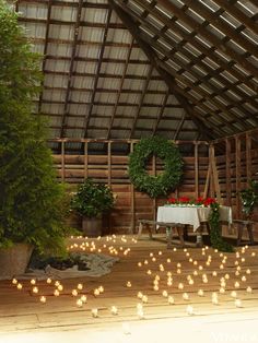 candles are arranged in the shape of letters on a wooden floor next to potted plants