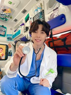 a young man sitting in the back of a car holding a stethoscope